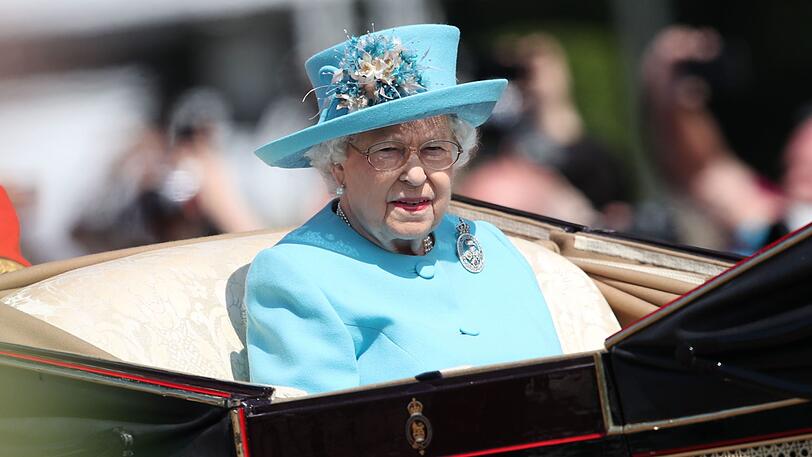 Ganz in türkis: die Queen kommt in der Kutsche angefahren.