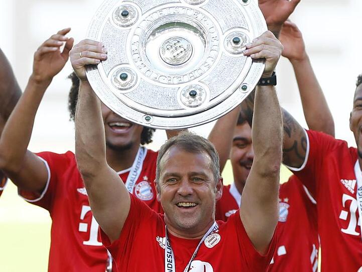 Trainer Hansi Flick (M) von Bayern hält nach dem Spiel die Meisterschale. Foto: Kai Pfaffenbach/Reuters-Pool/dpa