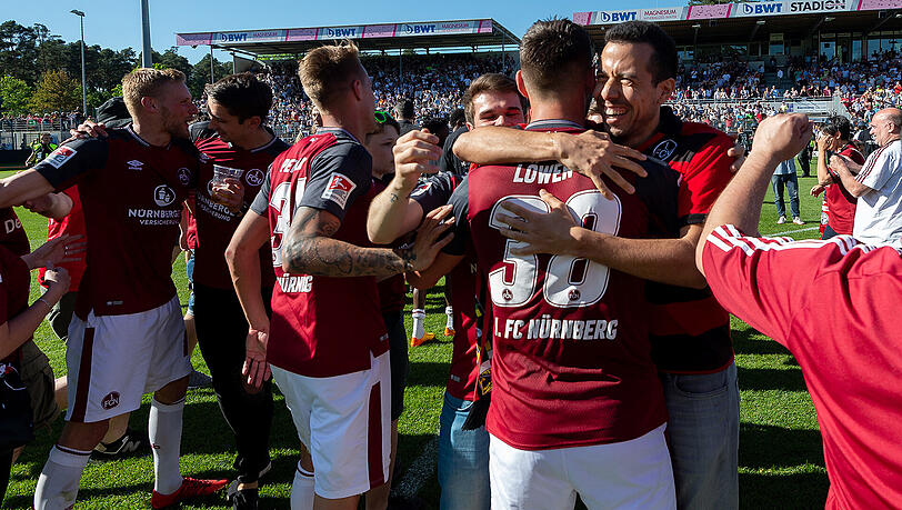 Freude pur: die Spieler des FC Nürnberg liegen sich nach dem geglückten Aufstieg in den Armen, im Hintergrund stürmen die Fans den Platz. Freude pur: die Spieler des FC Nürnberg liegen sich nach dem geglückten Aufstieg in den Armen, im Hintergrund stürmen die Fans den Platz.