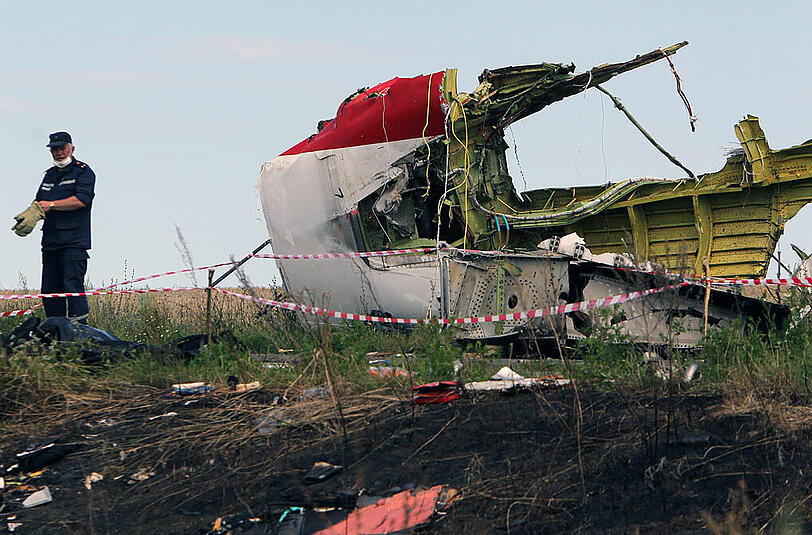 Gespenstisches Bild: Ein ukrainischer Arbeiter an der Absturzstelle von Flug MH17 der Malaysia Airlines in der Ostukraine.
