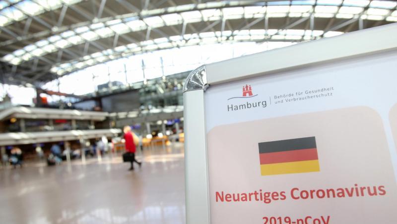 Auf einem Aufsteller der Gesundheitsbörde und des Robert Koch-Instituts wird im mäßig gefüllten Hamburger Flughafen auf Verhaltensweisen in Bezug auf das Coronavirus hingewiesen. Auf einem Aufsteller der Gesundheitsbörde und des Robert Koch-Instituts wird im mäßig gefüllten Hamburger Flughafen auf Verhaltensweisen in Bezug auf das Coronavirus hingewiesen.