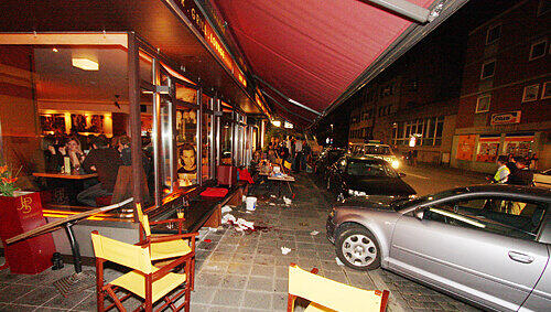 Der Audi (re.) erwischte an dem Samstagabend zwei Außen-Tische, an denen Gäste der „Stockholm Bar“ saßen. Fünf Männer und drei Frauen wurden verletzt. Der Audi (re.) erwischte an dem Samstagabend zwei Außen-Tische, an denen Gäste der „Stockholm Bar“ saßen. Fünf Männer und drei Frauen wurden verletzt.