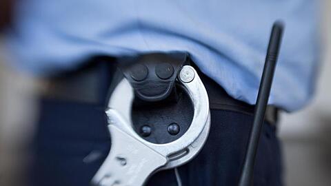 Handschellen hängen am Gürtel eines Justizbeamten. Foto: Friso Gentsch/dpa/Symbolbild