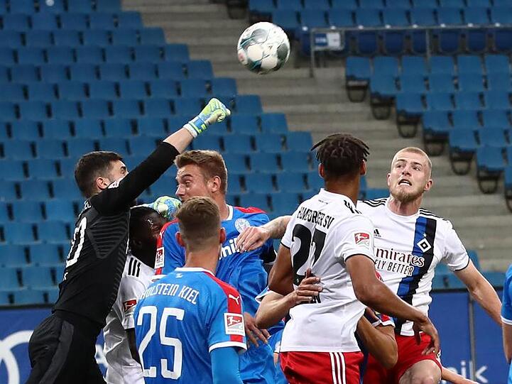 Der Kieler Torwart Ioannis Gelios (l-r) faustet den Ball vor seinen Teamkameraden Phil Neumann, Hauke Wahl und den Hamburgern Josha Vagnoman und Rick van Drongelen weg.