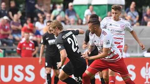 Augsburgs Fredrik Jensen (l) und der Greifswalder Rudolf Sanin k&auml;mpfen um den Ball.
