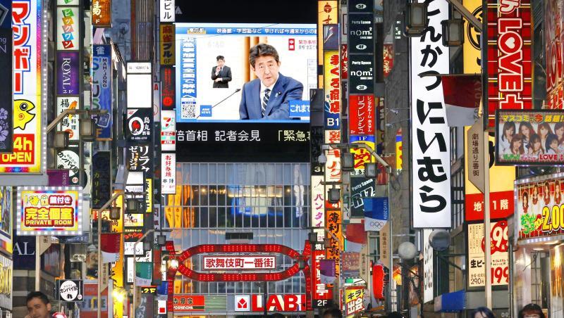 Eine große Leinwand in Tokio zeigt den japanischen Premierminister Shinzo Abe, der das Ende des Ausnahmezustands verkündet. Eine große Leinwand in Tokio zeigt den japanischen Premierminister Shinzo Abe, der das Ende des Ausnahmezustands verkündet.