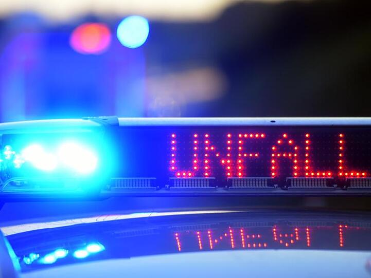 Auf einem Polizeifahrzeug warnt eine Leuchtschrift vor einer Unfallstelle. Foto: Stefan Puchner/dpa/Symbolbild
