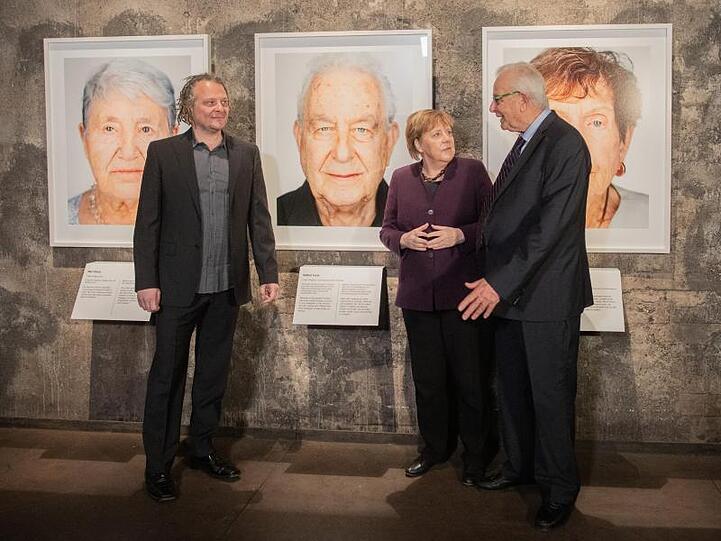 Der Künstler Martin Schoeller (l), der Holocaust-Überlebende Naftali Fürst und Bundeskanzlerin Angela Merkel (CDU) bei der Eröffnung der Ausstellung "Survivors - Faces of Life after the Holocaust" in Essen.