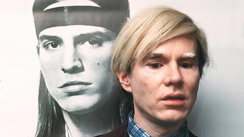 Der Künstler Andy Warhol vor einem seiner Bilder.