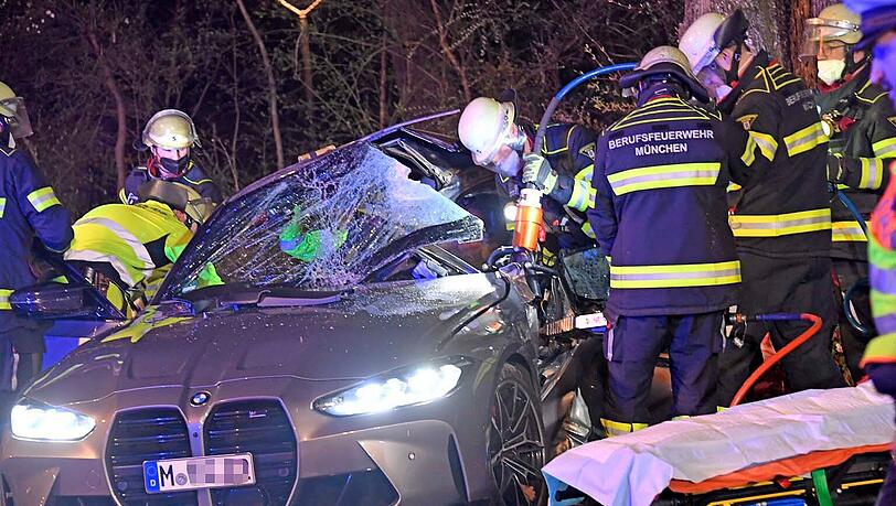 Die Feuerwehr schneidet das Wrack des Autos auf, das auf der Rosenheimer Straße gegen einen Baum geknallt war.