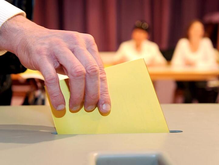 Ein Wahlzettel wird in eine Wahlurne gesteckt. Foto: Bernd Weissbrod/Archiv