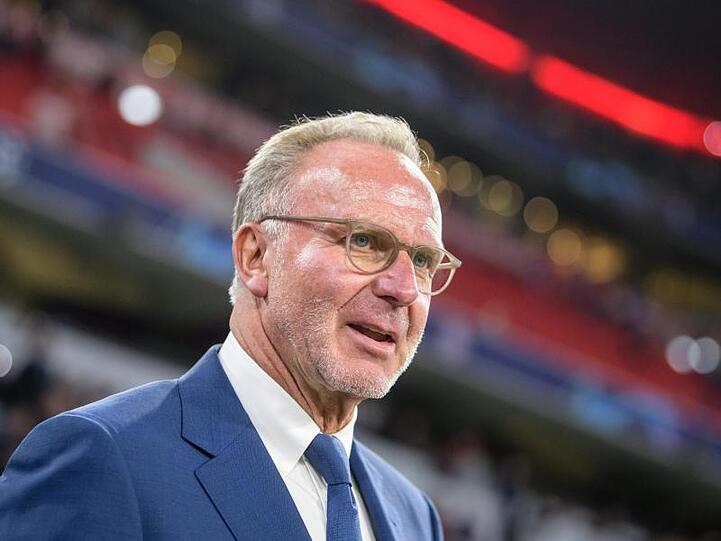 Karl-Heinz Rummenigge steht im Stadion am Spielfeldrand. Foto: Matthias Balk/dpa/Archivbild