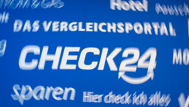 Das Logo von Check24 sowie zahlreiche Slogans sind auf einem Banner in der Zentrale des Vergleichsportals Check24 in München zu sehen.
