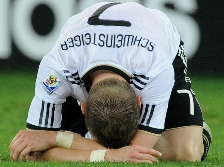 Bastian Schweinsteiger kauert nach dem verlorenen Halbfinale auf dem Rasen.