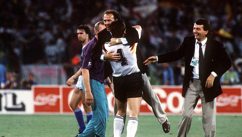 Teamchef Franz Beckenbauer (li.) feiert in den Armen von Jürgen Kohler den Weltmeistertitel, Rechts: DFB Pressesprecher Wolfgang Niersbach.