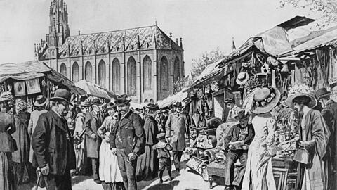 Die Zeichnung zeigt die Tandelmarkt auf der Auer Dult etwa im Jahr 1910. Seit 1905 ist die Jakobidult, die zuvor am Johannisplatz in Haidhausen stattfand, auf den Mariahilfplatz umgezogen.