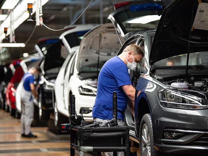 Autoproduktion mit Mund- und Nasenschutz. Die Branche fordert höhere Kaufprämien, um die eingebrochene Nachfrage anzukurbeln.