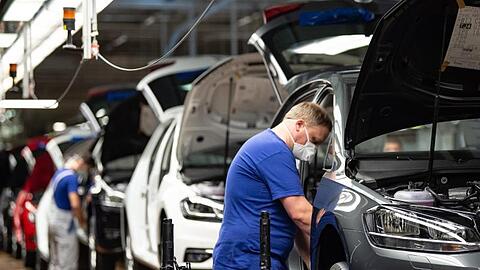 Autoproduktion mit Mund- und Nasenschutz. Die Branche fordert höhere Kaufprämien, um die eingebrochene Nachfrage anzukurbeln.