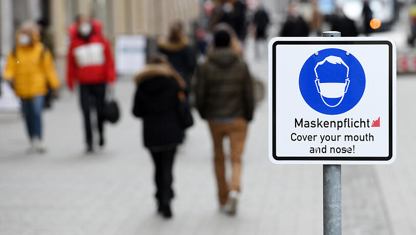 Ein Schild weist in der Münchner Innenstadt auf die Maskenpflicht hin. Die gilt ab dem morgigen Mittwoch nicht mehr.