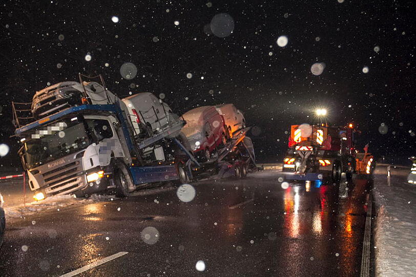 Ein Autotransporter rutscht aufgrund der schneeglatten Fahrbahn in den Graben