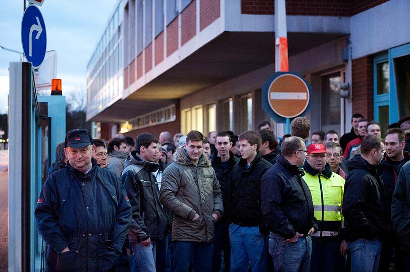 Mitarbeiter des insolventen Druckmaschinenherstellers Manroland stehen am Montag (23.01.12) in Offenbach am Main im Rahmen einer Demonstration am Rand einer Betriebsversammlung vor einem Werk des Unternehmens.