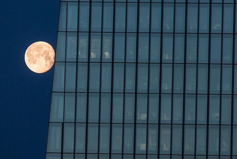 Der Mond geht hinter dem EZB-Turm in Frankfurt unter.
