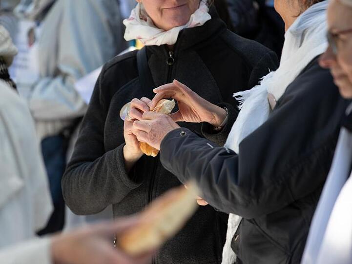 Beim Gottesdienst unter freiem Himmel wird Brot gebrochen.
