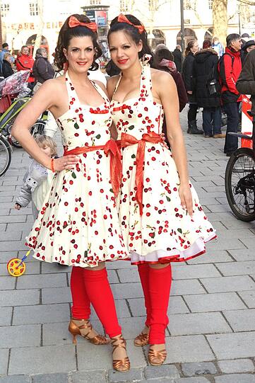 Nina Maric, 31 (links) und Sabrina Spickermann, 23 (rechts), beide Rechtsanwaltsfachangestellte, gehören zum Gardeverein der Würmesia. Nina: &bdquo;Ich bin Vizepräsidentin der Würmesia und natürlich Gardemitglied. Dieses Jahr haben wir das Motto 50er Jahre, deshalb natürlich der Petticoat, der war damals ja total in. Aber auch die Kirschen erinnern an diese Zeit, an Rockabilly oder Elvis, der ja zu dieser Zeit eine Ikone war. Ich würde am liebsten immer so rumlaufen. Die 50er waren einfach ein schönes Jahrzehnt! Im Moment kommt das ja auch wieder in Mode, allerdings in abgeschwächter Form.&ldquo; Sabrina: &bdquo;Damals waren solche Kleider normal, heute gehört schon viel Mut dazu, sowas im Alltag zu tragen. Da wird man in der U-Bahn wahrscheinlich angestarrt. In die Arbeit würde ich so nicht gehen, das wäre übertrieben.&ldquo;