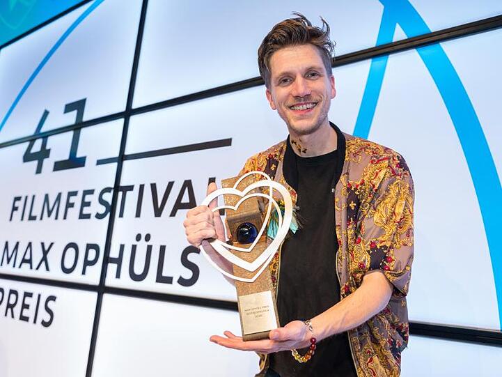Der Regisseur Johannes Maria Schmit zeigt seinen Preis, den er für den Film "Neubau" erhielt.