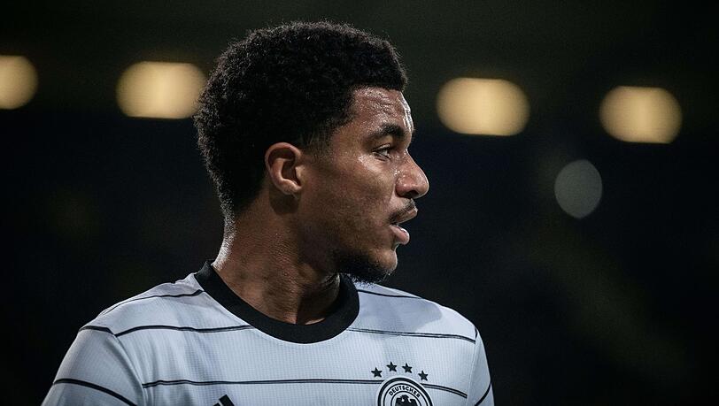 Malik Tillman guckt in Richtung Spielfeld.