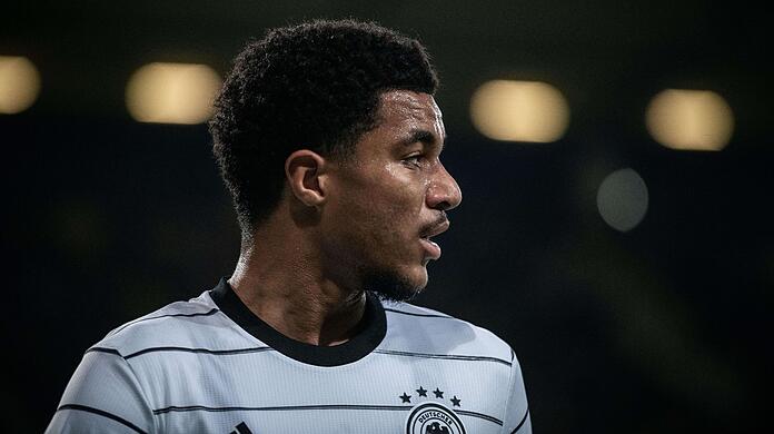 Malik Tillman guckt in Richtung Spielfeld.