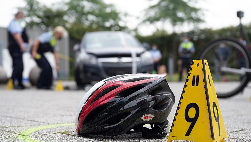 Ein Fahrradhelm liegt bei einer Verkehrsunfallaufnahme auf dem Boden.