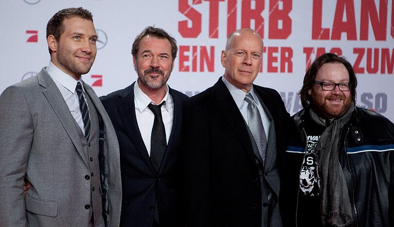 Die internationalen Stars Jai Courtney (aus Australien), Sebastian Koch (aus Deutschland) und US-Schauspieler Bruce Willis mit ihrem irischen Regisseur John Moore bei der "Stirb langsam"-Premiere in Berlin am Montagabend.