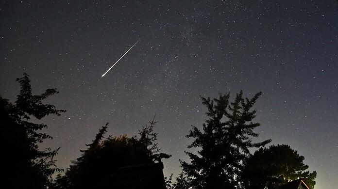 Ein Perseidenmeteor zieht über den Himmel.