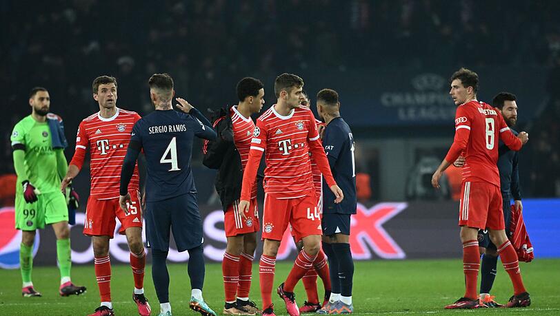 Spieler von Bayern und Paris stehen nach dem Spiel auf dem Platz.