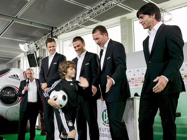 Joachim Löw (v.r.), Andreas Köpke, Hans-Dieter Flick und Oliver Bierhoff klatschen die Hand von Kindern in Fußballtrikots ab.