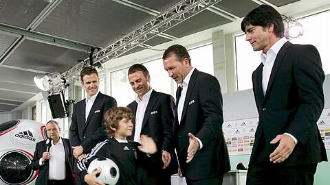 Joachim Löw (v.r.), Andreas Köpke, Hans-Dieter Flick und Oliver Bierhoff klatschen die Hand von Kindern in Fußballtrikots ab.