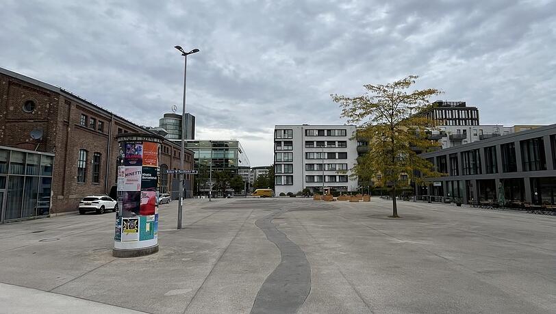 Gemütlich schaut anders aus: Das ist der Rainer-Werner-Fassbinder-Platz in Neuhausen-Nymphenburg. Die graue Pfütze vor dem weißen Gebäude ist übrigens ein Kunstwerk.