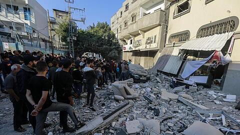 Anwohner und Passanten stehen nach dem israelischen Luftangriff vor dem beschädigten Haus von Baha Abu Al Ata.