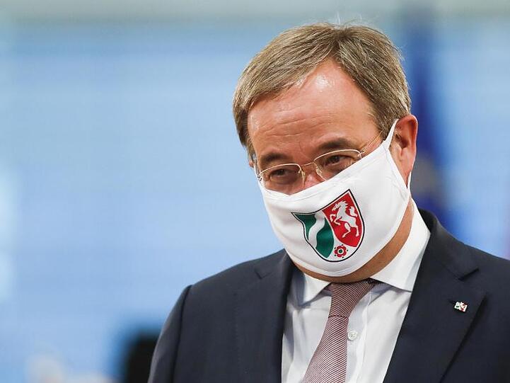 Ministerpräsident Armin Laschet mit einer Gesichtsmaske mit NRW-Wappen.
