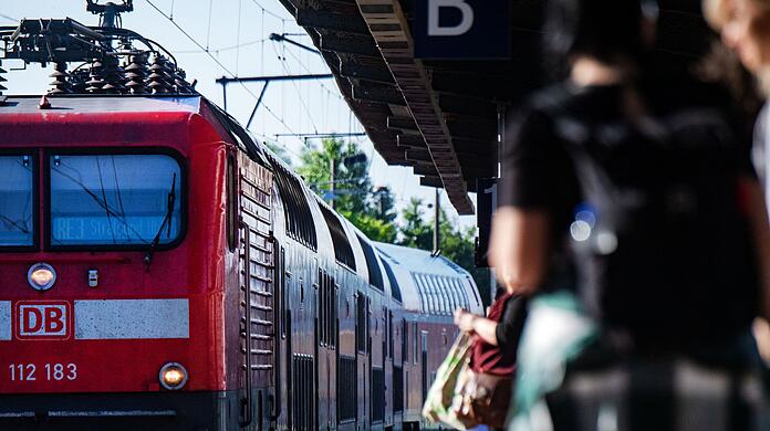 Fahrgäste warten im Bahnhof auf eine Regionalbahn.