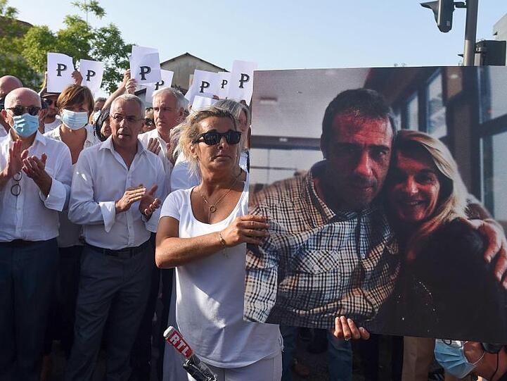Die Ehefrau des verstorbenen Busfahrers hält während eines Protestmarsches in Bayonne ein Foto von sich und ihrem Mann.