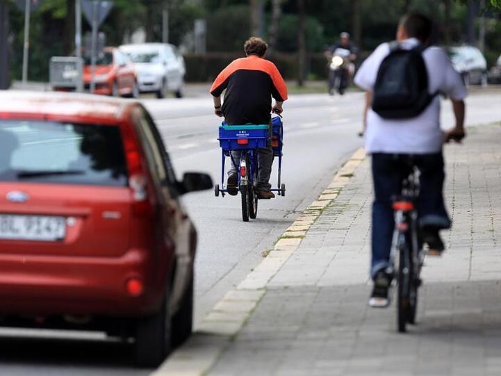 Wo auf der Fahrbahn der Platz nicht reicht, tut's auch der Gehweg: Ein Fahrradfahrer ist in München auf dem Bürgersteig unterwegs.
