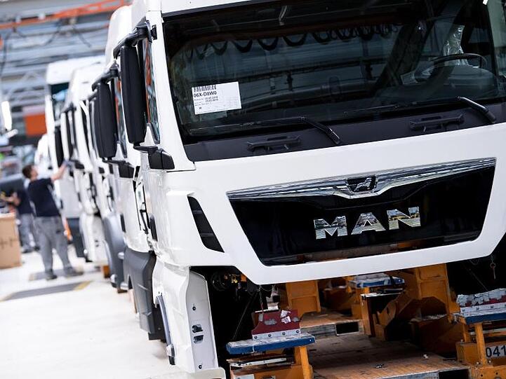Mitarbeiter von MAN arbeiten an einem LKW. Foto: Sven Hoppe/dpa/Archivbild