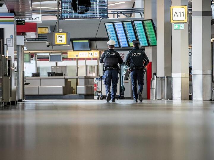 Polizisten patrouillieren am Flughafen Berlin-Tegel durch das Terminal.