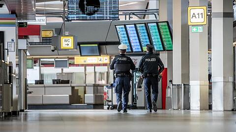 Polizisten patrouillieren am Flughafen Berlin-Tegel durch das Terminal.