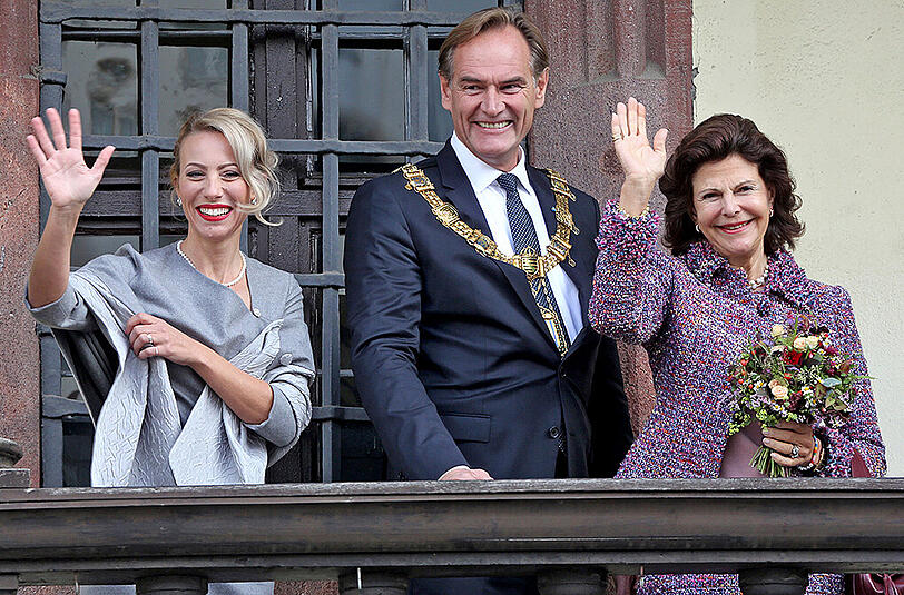 Leipzigs OB Burkhard Jung (SPD, M) und Frau Ayleena (l) stehen mit Königin Silvia von Schweden auf dem Balkon vom Alten Rathaus.