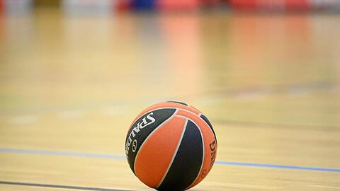 Ein Ball liegt auf einem Basketball-Spielfeld.