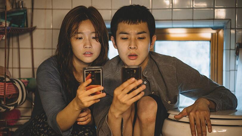 Für Wlan-Empfang kriechen Ki-jung (Park So Dam) und ihr Bruder Ki-woo (Choi Woo Shik) in das Nischenklo der Wohnung. Für Wlan-Empfang kriechen Ki-jung (Park So Dam) und ihr Bruder Ki-woo (Choi Woo Shik) in das Nischenklo der Wohnung.