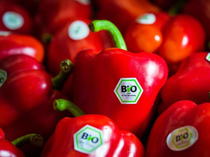 Rote Paprika mit Bio-Siegel liegen am Stand von Demeter auf der BioFach-Messe.